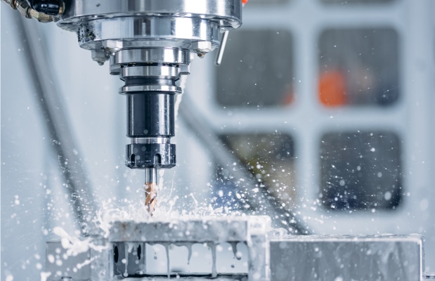 CNC-Fräsmaschine bearbeitet Metallwerkstück mit Kühlmittel – präzise Fertigung mit CAD/CAM-Software für CNC-Programmierung
